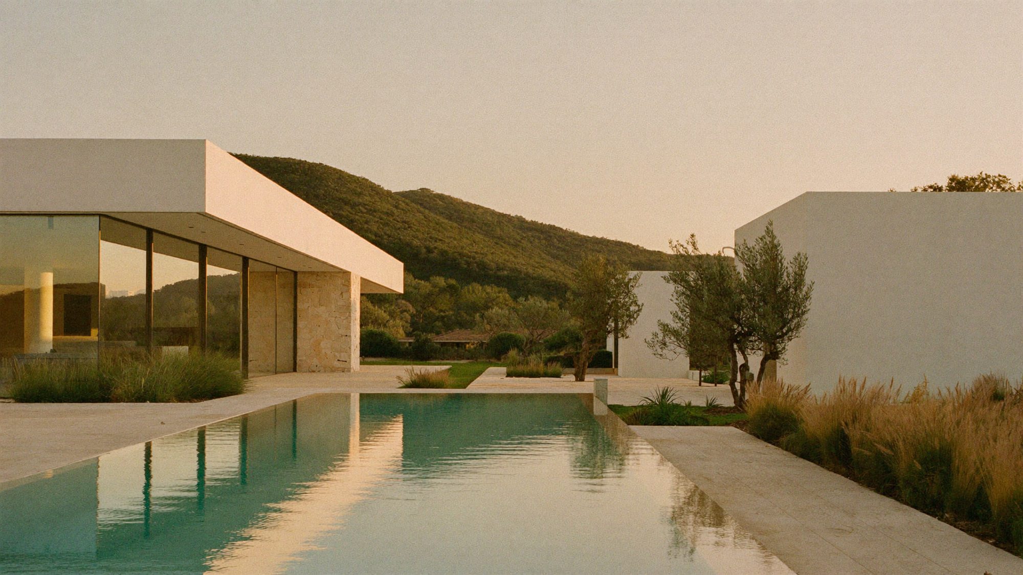 Moradia contemporânea com piscina e jardim mediterrânico ao fim da tarde